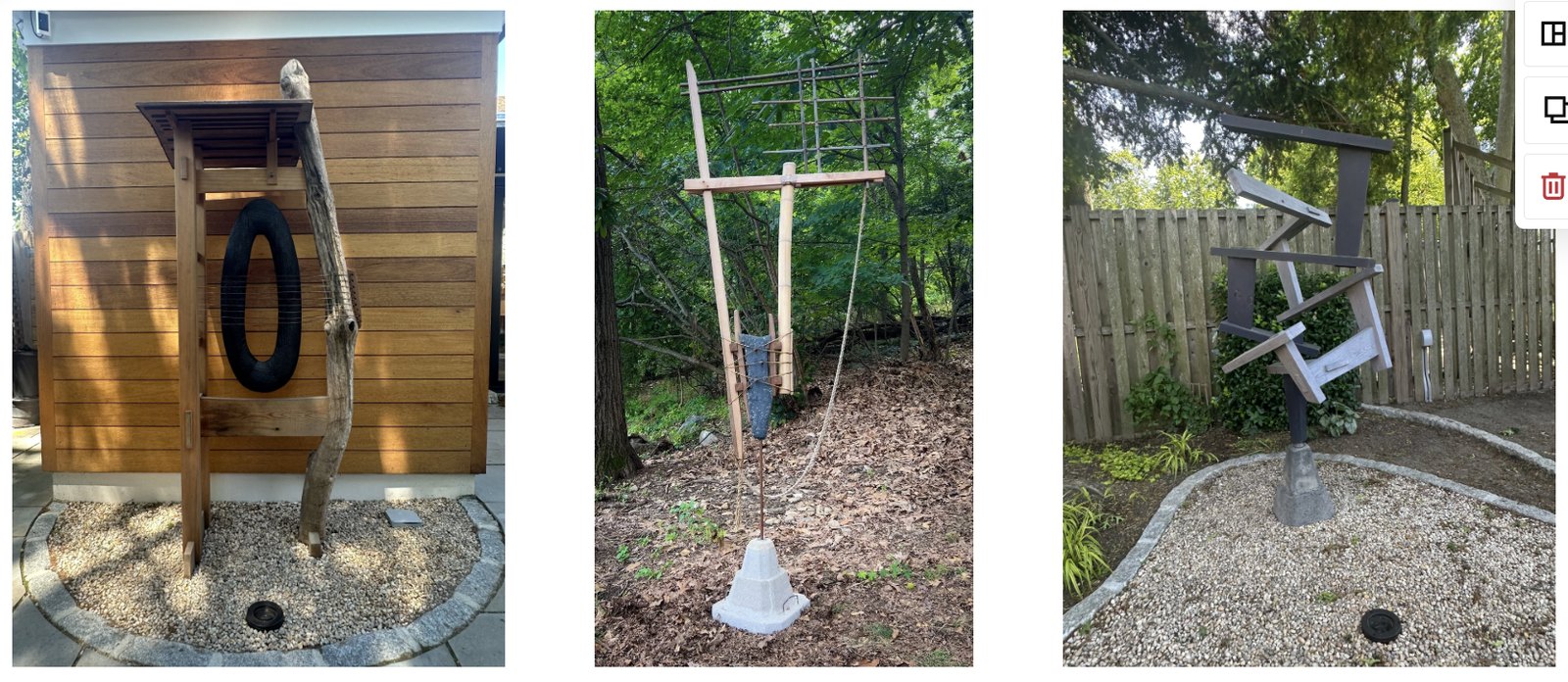 Three outdoor sculptures in wood and mixed materials, standing against a cedar wall, among trees and on a gravel bed